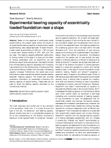 Experimental bearing capacity of eccentrically loaded foundation near a slope